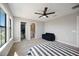 Bright bedroom featuring a large window, walk-in closet, ceiling fan and blue sofa at 16418 Slate Pl, Lakewood Ranch, FL 34211