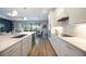 Modern kitchen with an island, white cabinets, and stainless appliances overlooking the dining and living areas at 16418 Slate Pl, Lakewood Ranch, FL 34211