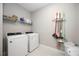 This laundry room offers a Whirlpool washer and dryer with a shelf above and space for cleaning supplies at 16418 Slate Pl, Lakewood Ranch, FL 34211