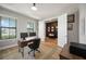 Bright home office with hardwood floors, a desk, and a view of a room at 16418 Slate Pl, Lakewood Ranch, FL 34211