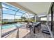 Spacious covered patio with outdoor dining set, overlooking the pool, spa, and lake at 16418 Slate Pl, Lakewood Ranch, FL 34211