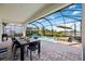 Covered patio with black dining set overlooks the pool and spa with scenic lake view at 16418 Slate Pl, Lakewood Ranch, FL 34211