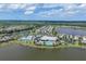 Breathtaking aerial view of a community with lush landscaping, pool, tennis courts, and beautiful homes surrounding a serene lake at 17850 Polo Trl, Bradenton, FL 34211