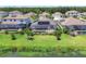 Rear view of a home with a screened-in pool area and solar panels, set by a picturesque lake at 17850 Polo Trl, Bradenton, FL 34211