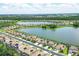 Aerial view of a lakefront community showcasing houses with solar panels on the roofs on a bright, sunny day at 17850 Polo Trl, Bradenton, FL 34211