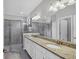 Bathroom featuring granite counters, double sinks, and walk-in shower at 17850 Polo Trl, Bradenton, FL 34211