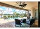 Screened patio with a seating area looking out to the pool, the lake and the lush surrounding foliage at 17850 Polo Trl, Bradenton, FL 34211