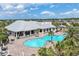 Community clubhouse and swimming pool with palm trees, lounge seating, and Gathering fun at 17850 Polo Trl, Bradenton, FL 34211