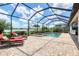 Inviting screened-in pool area with lounge chairs and a scenic lake view at 17850 Polo Trl, Bradenton, FL 34211