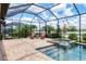 Beautiful screened-in pool and patio with lounge seating and waterfront views at 17850 Polo Trl, Bradenton, FL 34211