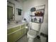 Standard bathroom with a green vanity, toilet, and shelving unit, providing ample storage space at 1999 Kings Hwy # 26A, Punta Gorda, FL 33980