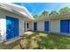 Exterior view of home showcasing blue doors and well-maintained landscaping at 2400 Lake Shore Dr, Nokomis, FL 34275
