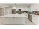 Modern kitchen with white cabinetry, stainless steel appliances, and a large center island at 2400 Lake Shore Dr, Nokomis, FL 34275