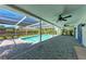 Screened-in pool area featuring a paved patio and ceiling fans for outdoor comfort at 2400 Lake Shore Dr, Nokomis, FL 34275