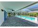 Covered pool area featuring a paved patio, ceiling fans, and views of the backyard at 2400 Lake Shore Dr, Nokomis, FL 34275