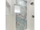 Modern shower featuring beautiful stone tile, a showerhead, and a built-in niche for storage at 2400 Lake Shore Dr, Nokomis, FL 34275