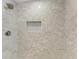 Modern shower featuring a showerhead, sleek light gray tile, and a built-in niche for storage at 2400 Lake Shore Dr, Nokomis, FL 34275