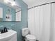 Retro turquoise bathroom with tile, classic fixtures, and a shower with a white curtain at 2416 Emory Ave, Bradenton, FL 34207