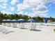 Pool area with tables and chairs under umbrellas, providing a comfortable outdoor space at 2416 Emory Ave, Bradenton, FL 34207