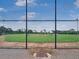 A fenced baseball field with green grass and a clear sky, ensuring safety and visibility at 245 Cape Harbour Loop # 103, Bradenton, FL 34212