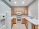 Well-lit kitchen with white appliances, wood cabinets, and ample counter space for cooking at 245 Cape Harbour Loop # 103, Bradenton, FL 34212