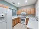 Bright kitchen featuring white countertops, wood cabinets, and modern appliances at 245 Cape Harbour Loop # 103, Bradenton, FL 34212