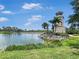 A lighthouse next to a lake surrounded by palm trees in a luxurious Florida community at 245 Cape Harbour Loop # 103, Bradenton, FL 34212
