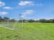 A soccer goal stands in a green field beneath a blue sky, with trees in the background at 245 Cape Harbour Loop # 103, Bradenton, FL 34212