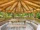 Wooden gazebo interior with picnic table and seating showcasing natural light and craftsmanship at 2748 Orchid Oaks Dr # 202, Sarasota, FL 34239