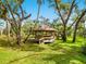 Picturesque gazebo with a brown roof surrounded by a lush green lawn and shady trees at 2748 Orchid Oaks Dr # 202, Sarasota, FL 34239