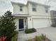 Inviting two-story home with a blue front door, attached two-car garage, and landscaped front yard at 2824 Rock Sound St, Bradenton, FL 34208