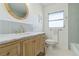 Bright bathroom featuring a wood vanity with granite top, modern fixtures, and decorative mirror at 3011 Bougainvillea St, Sarasota, FL 34239
