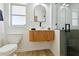 Well-lit bathroom showcasing the modern vanity, arched mirror, toilet, and walk-in shower at 3011 Bougainvillea St, Sarasota, FL 34239
