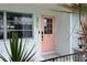 Close-up of the home's pretty pink front door flanked by plants and modern house numbers at 3011 Bougainvillea St, Sarasota, FL 34239
