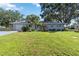 Charming single-story home with a lush lawn, mature trees, and beautifully landscaped garden beds at 3011 Bougainvillea St, Sarasota, FL 34239