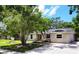 Single story home featuring mature landscaping, a green lawn, and a concrete driveway and walkway at 3236 Kingswood Dr, Sarasota, FL 34232