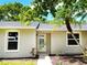 Home exterior featuring bright white trim, front door with decorative glass, and manicured landscaping at 3236 Kingswood Dr, Sarasota, FL 34232