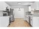 Modern kitchen featuring white cabinets, stainless appliances, stylish hardware, and wood-look floors at 3236 Kingswood Dr, Sarasota, FL 34232