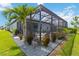 Landscaped backyard with a screened-in patio, complete with stylish outdoor seating and lush greenery at 3602 Quiet Dr, Sarasota, FL 34240