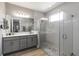 A bathroom featuring dual sinks, a large mirror, and a modern walk in shower at 3602 Quiet Dr, Sarasota, FL 34240