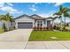 Charming single-story home with a manicured lawn, palm trees, and a gray two car garage at 3602 Quiet Dr, Sarasota, FL 34240