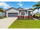 Charming single-story home with a manicured lawn, palm trees, and a gray two car garage at 3602 Quiet Dr, Sarasota, FL 34240