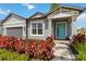 Beautiful exterior view with a manicured lawn, vibrant red shrubs, and a turquoise front door at 3602 Quiet Dr, Sarasota, FL 34240