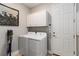 Bright laundry room features a modern washer and dryer, storage cabinets, and artwork at 3602 Quiet Dr, Sarasota, FL 34240