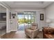 Bright living room with a leather chair and sliding glass doors leading to the outdoor pool at 3602 Quiet Dr, Sarasota, FL 34240