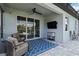 Covered patio featuring a ceiling fan, outdoor seating, and a stylish blue patterned rug at 3602 Quiet Dr, Sarasota, FL 34240