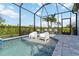 Gorgeous screened-in pool with inviting seating and a relaxing water feature; perfect for entertaining at 3602 Quiet Dr, Sarasota, FL 34240