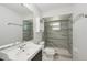 Modern bathroom with a large mirror, gray tile shower, and a white sink at 4023 Hina Dr, Sarasota, FL 34241