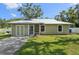 Charming single-story home with a well-maintained lawn and a classic, inviting facade with metal roof at 4023 Hina Dr, Sarasota, FL 34241
