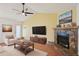 Cozy living room features a stone fireplace, vaulted ceiling with fan, and neutral decor at 4023 Hina Dr, Sarasota, FL 34241